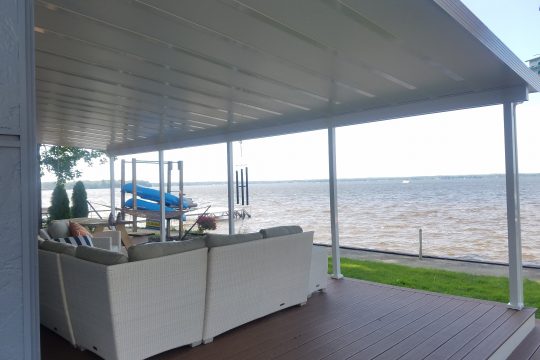 Insulated white patio roof with clean finished underside over a lakeside deck
