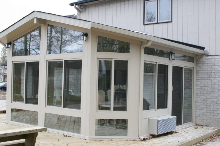 Betterliving sunroom with sloped roof and large sliding windows on a backyard deck
